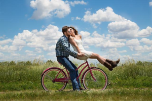 couple on bike to show a alternative date idea that is healthy and cheap